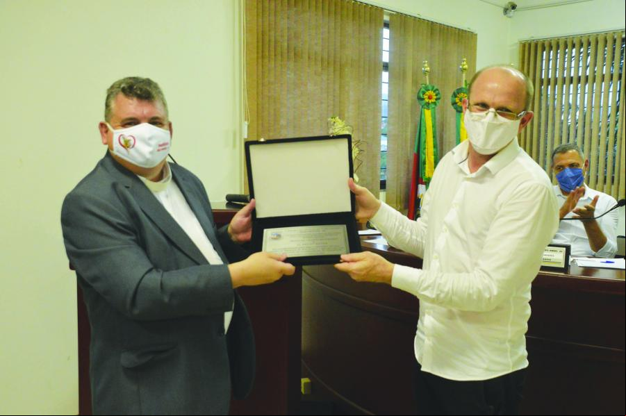 Padre Dirceu recebe a placa do vereador Darlei